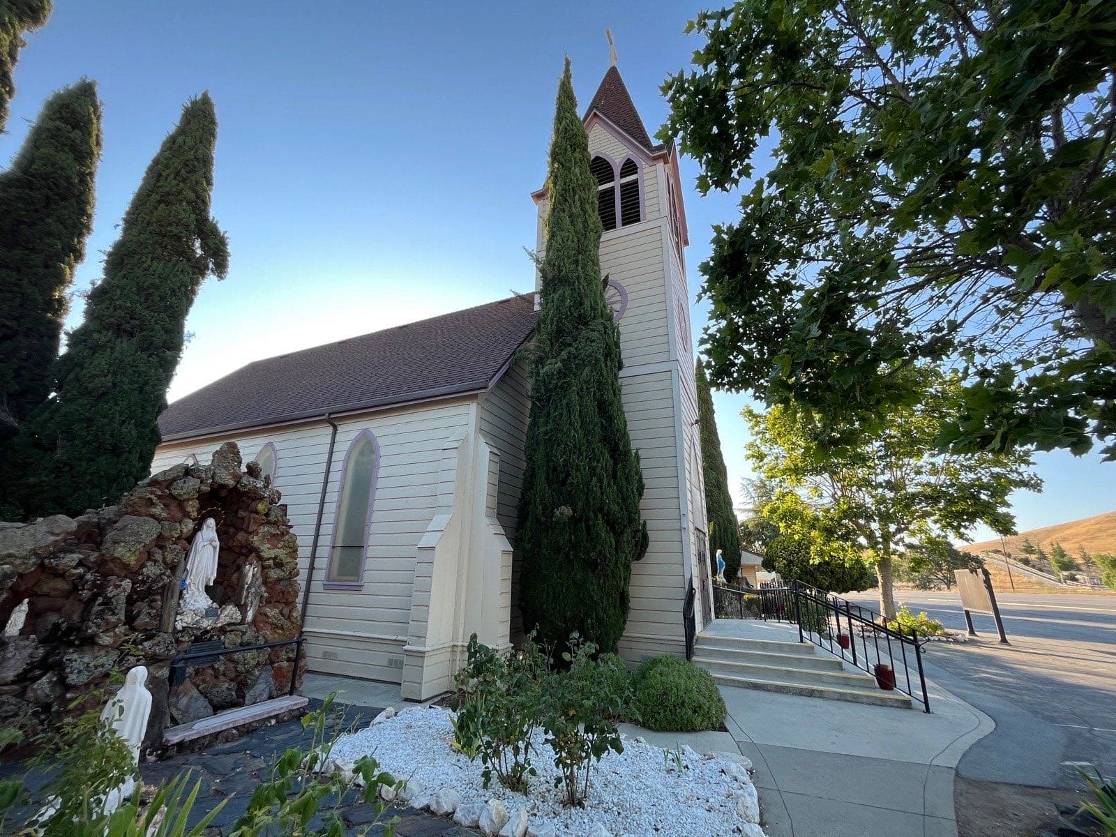 The grotto of Our Lady beside the Immaculate Conception church, framed by cypress trees